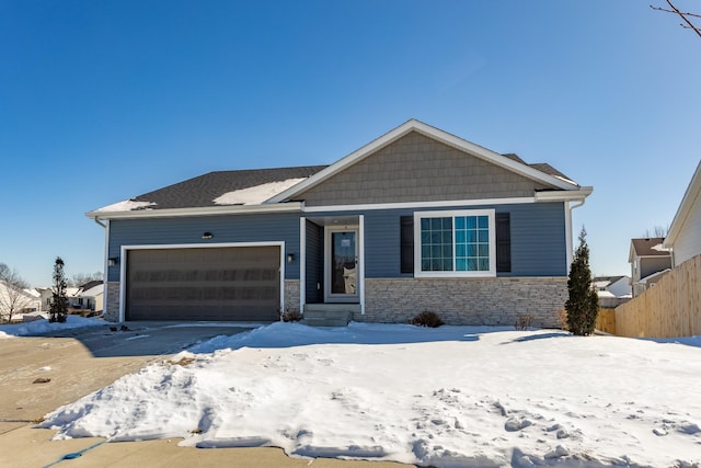 view of front of home featuring an attached garage, stone siding, fence, and entry steps