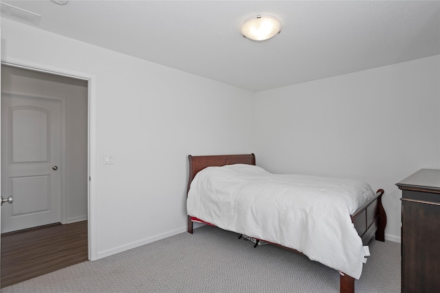 bedroom featuring visible vents, baseboards, and dark carpet