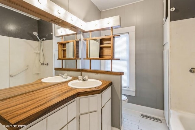 full bathroom featuring toilet, a shower, vanity, and visible vents