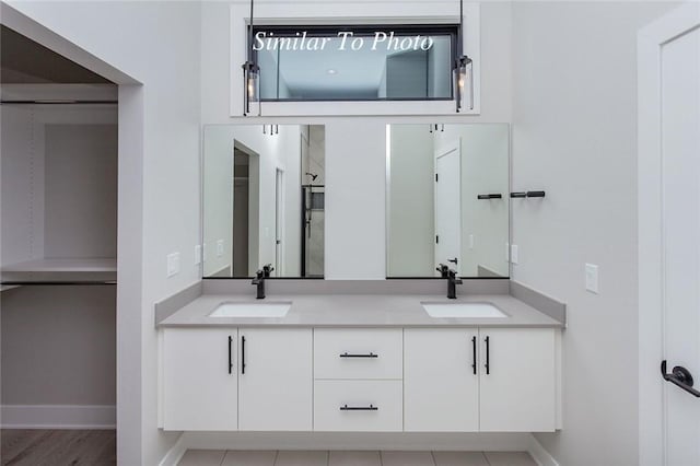 bathroom with double vanity, baseboards, and a sink