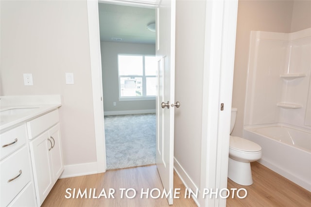 full bath with baseboards, bathing tub / shower combination, toilet, wood finished floors, and vanity