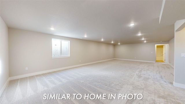 spare room with recessed lighting, light colored carpet, and baseboards