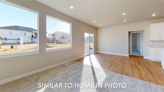 spare room featuring recessed lighting, visible vents, baseboards, light wood-style floors, and a residential view