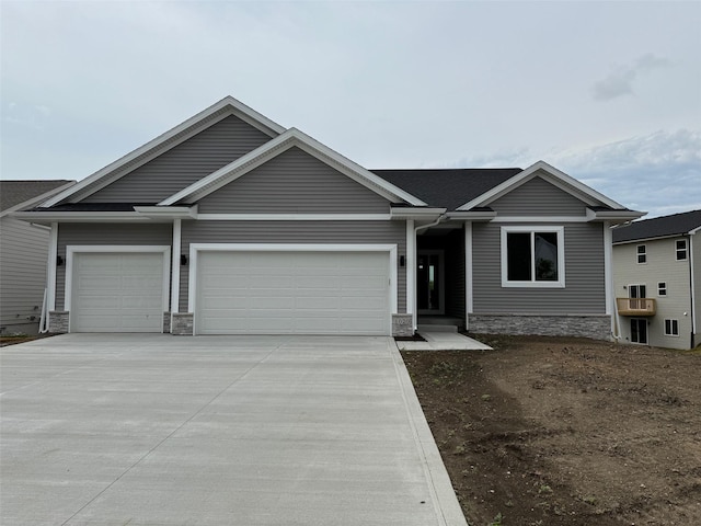 1020 2nd St NE, Altoona, IA 50009 - view of front of property featuring stone siding, concrete driveway, and a garage