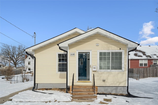 bungalow-style home featuring entry steps and fence