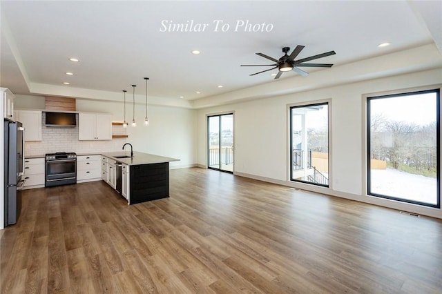 kitchen featuring stainless steel appliances, white cabinets, open floor plan, hanging light fixtures, and open shelves