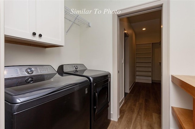 clothes washing area with dark wood-style floors, washer and clothes dryer, and cabinet space