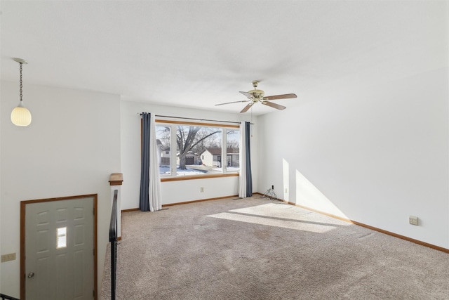 spare room with baseboards and light colored carpet