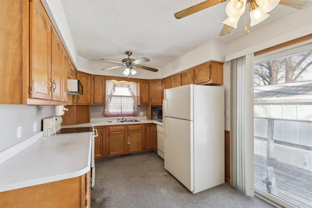 kitchen with white appliances, light countertops, and brown cabinetry