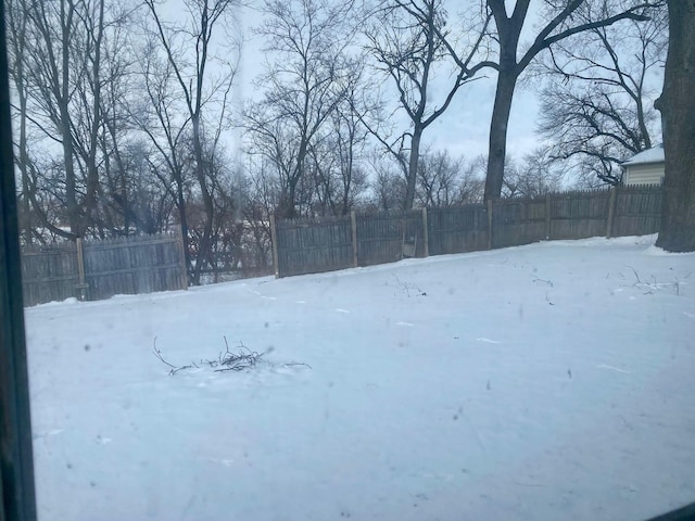 snowy yard featuring fence