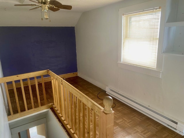 staircase with a baseboard heating unit, vaulted ceiling, baseboards, and ceiling fan