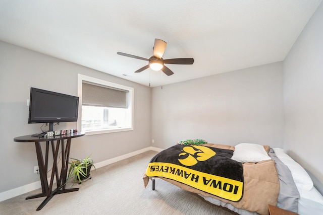 bedroom featuring light colored carpet, ceiling fan, and baseboards