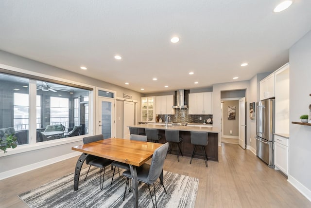 dining room with light wood-style flooring, baseboards, and recessed lighting