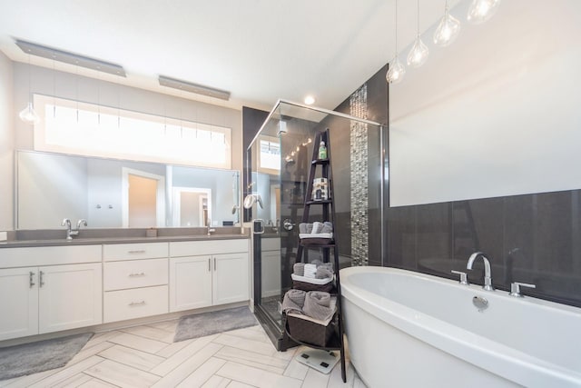 full bath featuring double vanity, a stall shower, a sink, and a freestanding bath