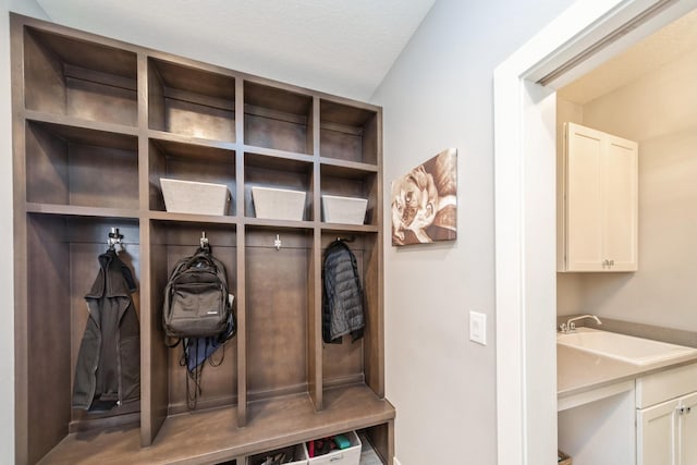 mudroom featuring a textured ceiling and a sink