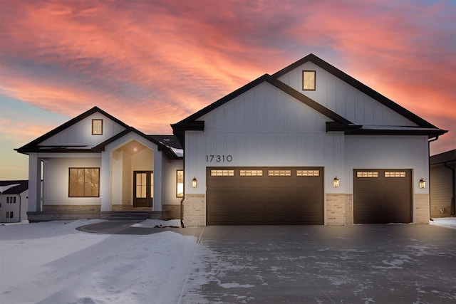 modern farmhouse style home with a garage, driveway, and board and batten siding