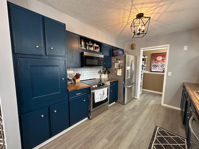 kitchen featuring wooden counters, appliances with stainless steel finishes, open shelves, and blue cabinetry