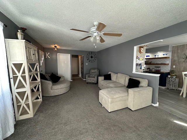 carpeted living room with a textured ceiling and a ceiling fan