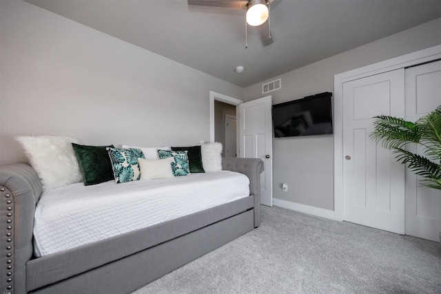 bedroom featuring a closet, light colored carpet, visible vents, a ceiling fan, and baseboards