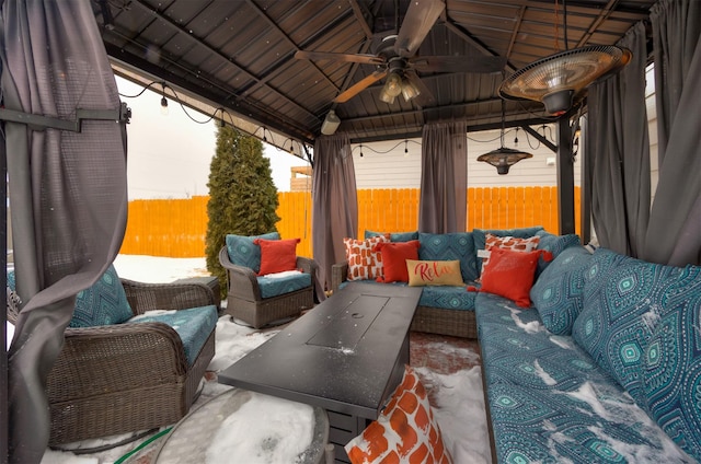 view of patio featuring ceiling fan, a gazebo, fence private yard, and an outdoor living space