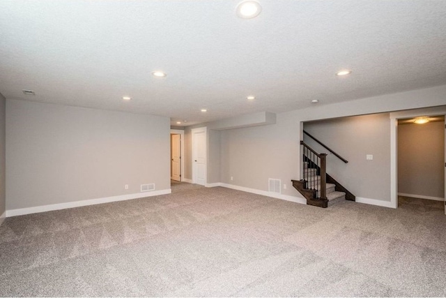 below grade area with carpet, stairs, visible vents, and recessed lighting