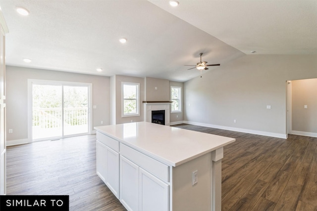 kitchen with a kitchen island, white cabinetry, open floor plan, and light countertops