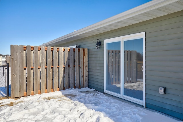 snow covered patio featuring fence