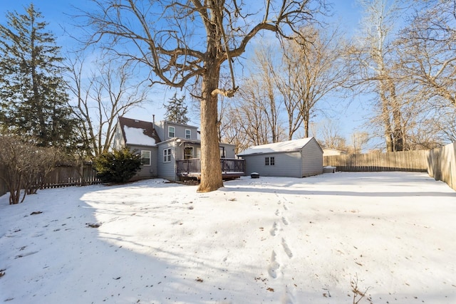 exterior space with a shed, fence, a deck, and an outdoor structure