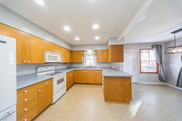 kitchen featuring a kitchen island, white appliances, brown cabinets, and a sink