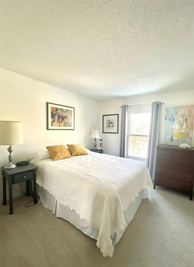 bedroom with light carpet and a textured ceiling