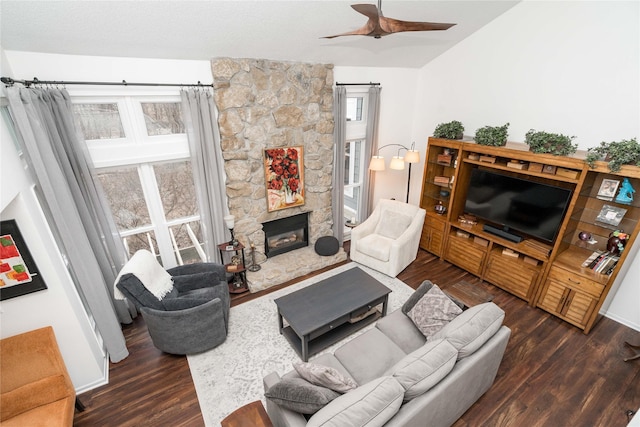 living room featuring a ceiling fan, lofted ceiling, a fireplace, and wood finished floors