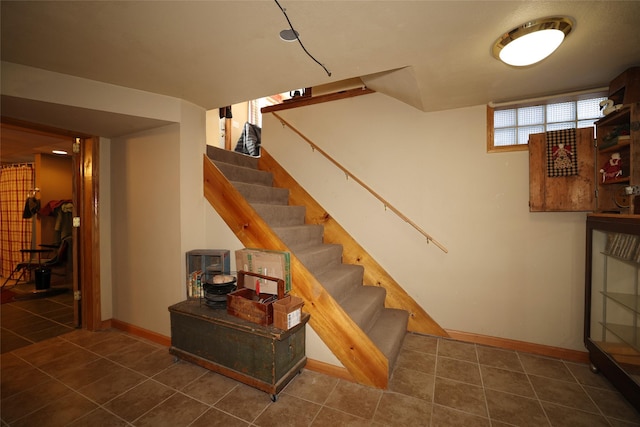 stairs featuring baseboards and tile patterned floors