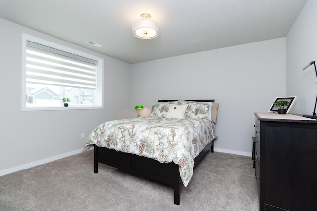 bedroom with light carpet, visible vents, and baseboards