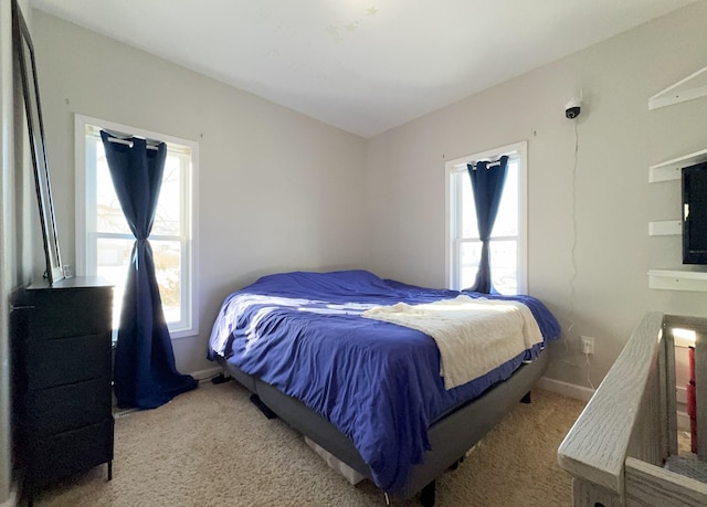 bedroom with baseboards and light colored carpet