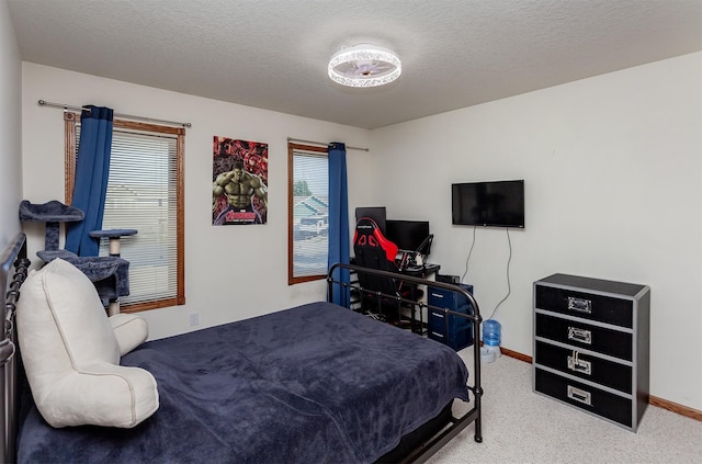 carpeted bedroom featuring a textured ceiling and baseboards