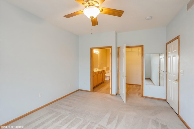 unfurnished bedroom featuring ceiling fan, ensuite bathroom, light carpet, visible vents, and baseboards