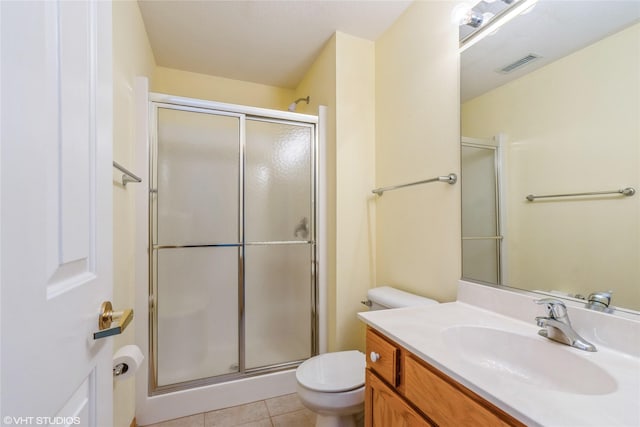 bathroom with toilet, a shower with shower door, vanity, visible vents, and tile patterned floors