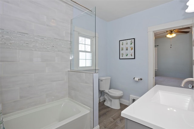 full bathroom with shower / washtub combination, toilet, a ceiling fan, vanity, and wood finished floors