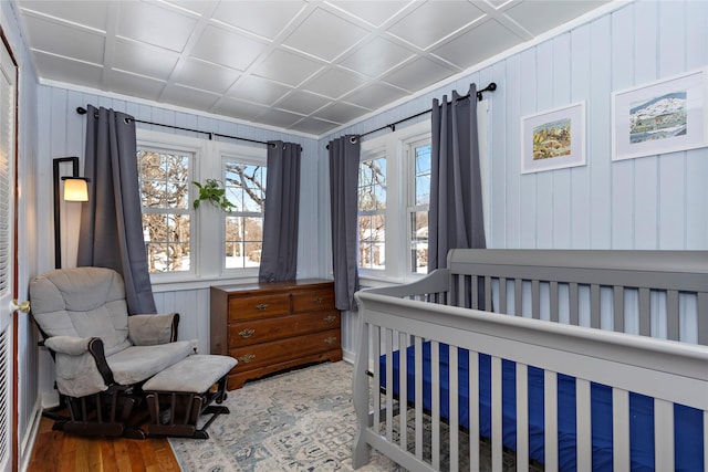 bedroom with a crib and wood finished floors