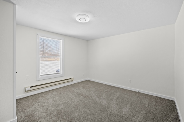 carpeted spare room with a baseboard radiator and baseboards