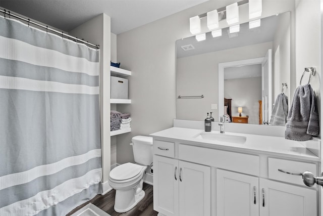 ensuite bathroom featuring visible vents, toilet, vanity, ensuite bath, and wood finished floors