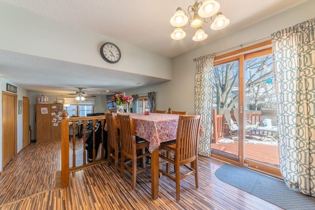 dining area with a wealth of natural light, a textured ceiling, and wood finished floors