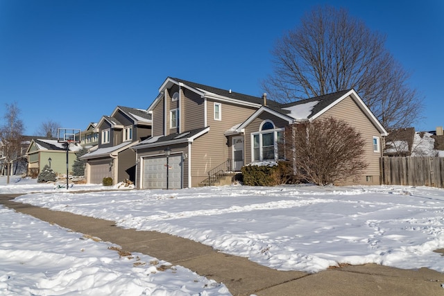 view of snow covered exterior featuring a residential view and an attached garage