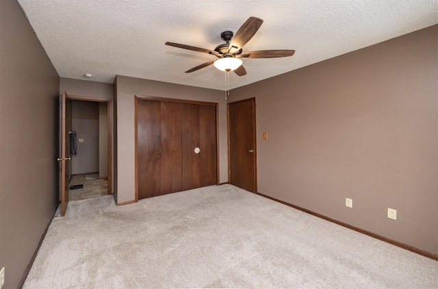 unfurnished bedroom with a closet, a ceiling fan, a textured ceiling, and light colored carpet