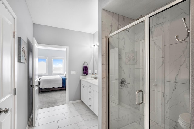 ensuite bathroom featuring a marble finish shower, marble finish floor, vanity, and ensuite bath