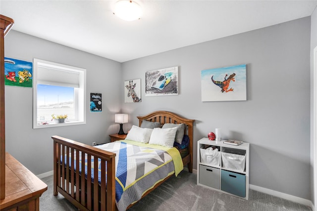 bedroom with baseboards and dark carpet