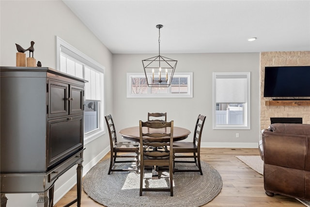 dining room featuring baseboards, plenty of natural light, and light wood finished floors