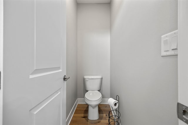 bathroom featuring wood finished floors, toilet, and baseboards