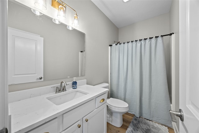 full bath featuring toilet, shower / bath combo, wood finished floors, and vanity