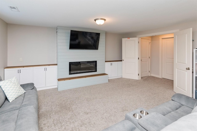 living room featuring light carpet, a large fireplace, and visible vents